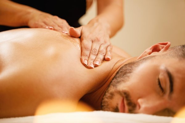 Man receiving gentle swedish massage of shoulder/neck