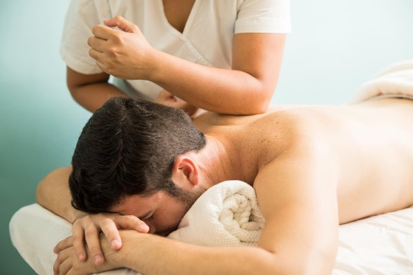Man receiving therapeutic massage of upper back